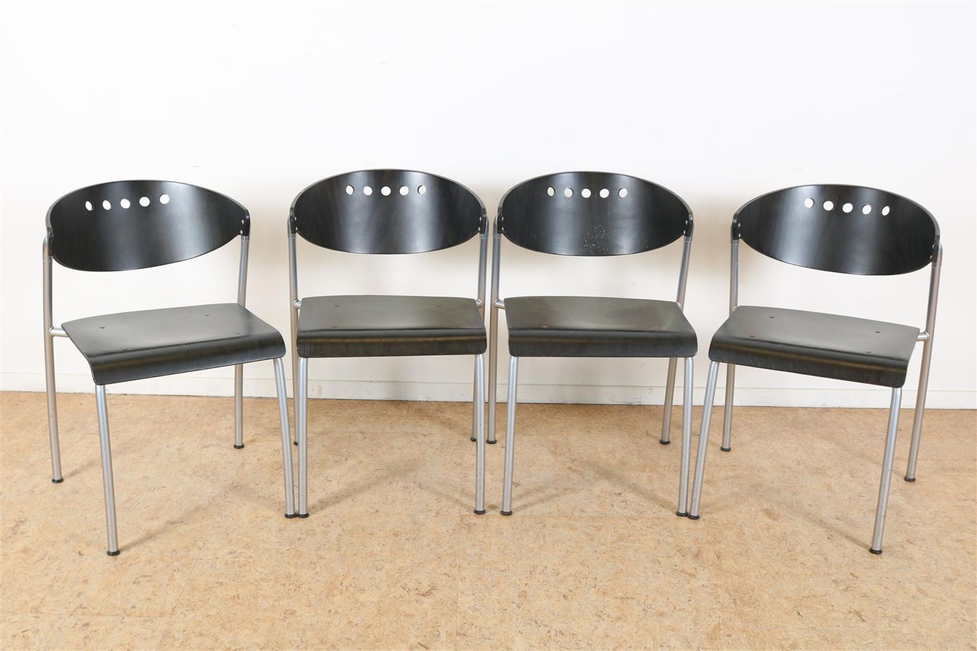 Series of 4 black-stained plywood chairs on chrome base.