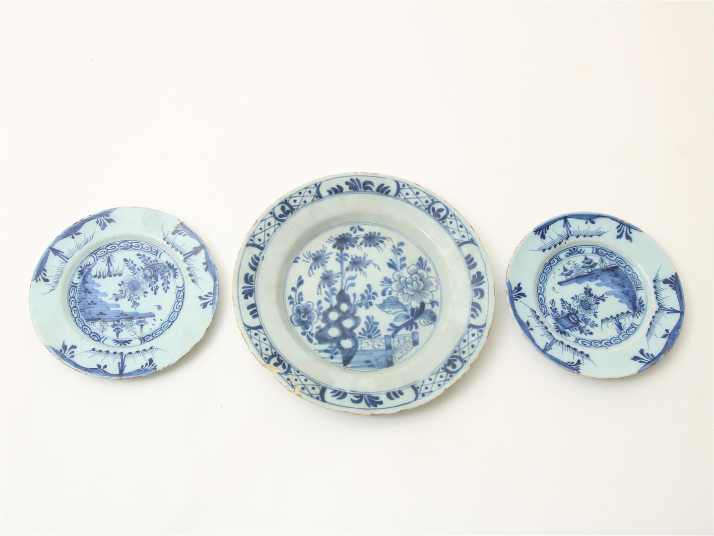 Lot of 3 earthenware plates, 2 with Chinoiserie decor and 1 decorated with flowers, Delft 18th