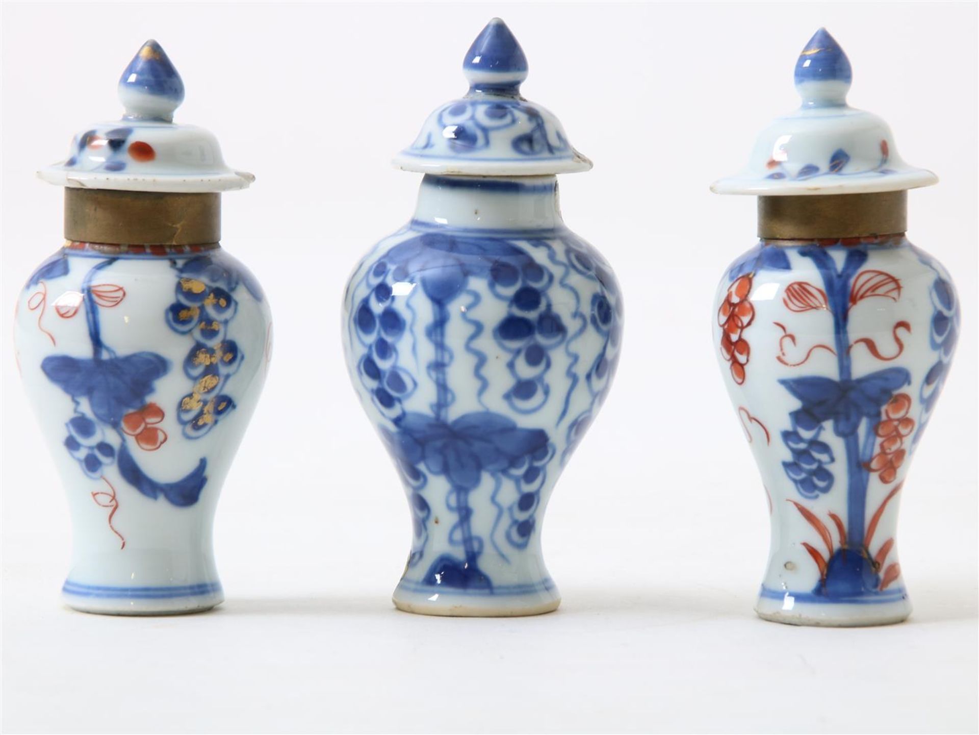 Set of porcelain miniature lidded vases with floral decor, height 10 cm. (edge restored and lids