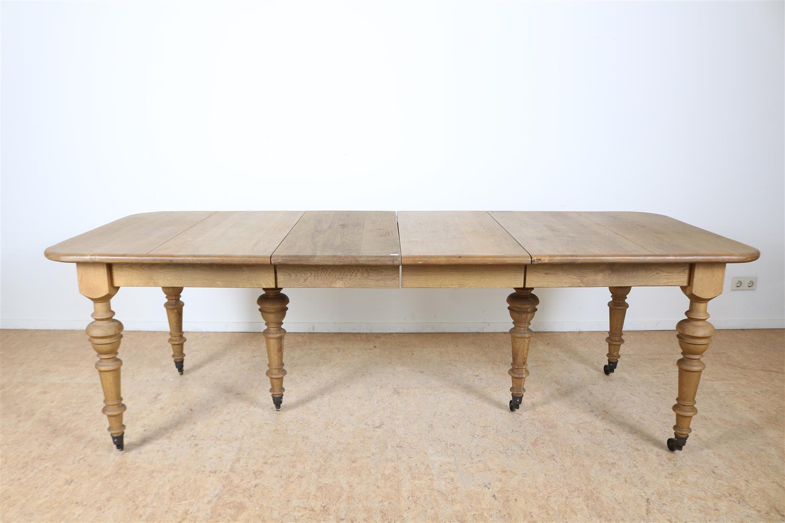 Oak wings table on turned legs ending in brass wheels, 78 x 162 x 98 cm. 2 oak intermediate leaves