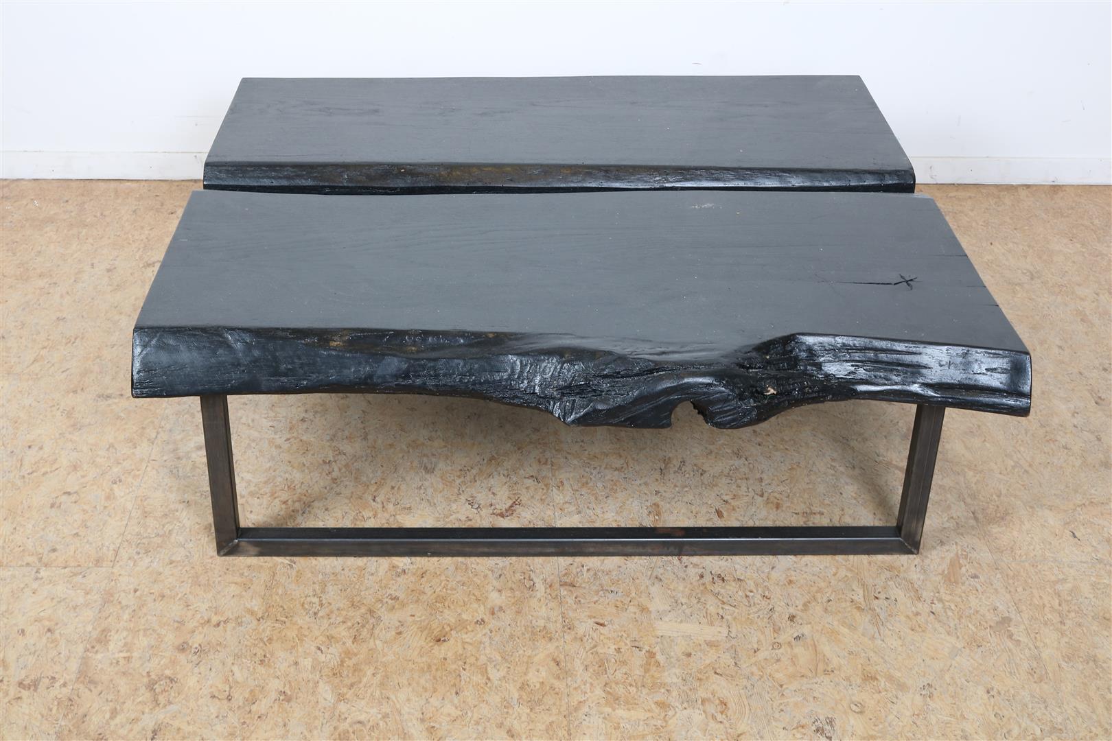 Black stained coffee table made of 2 tree trunks on an iron base, 34 x 110 x 110 cm.