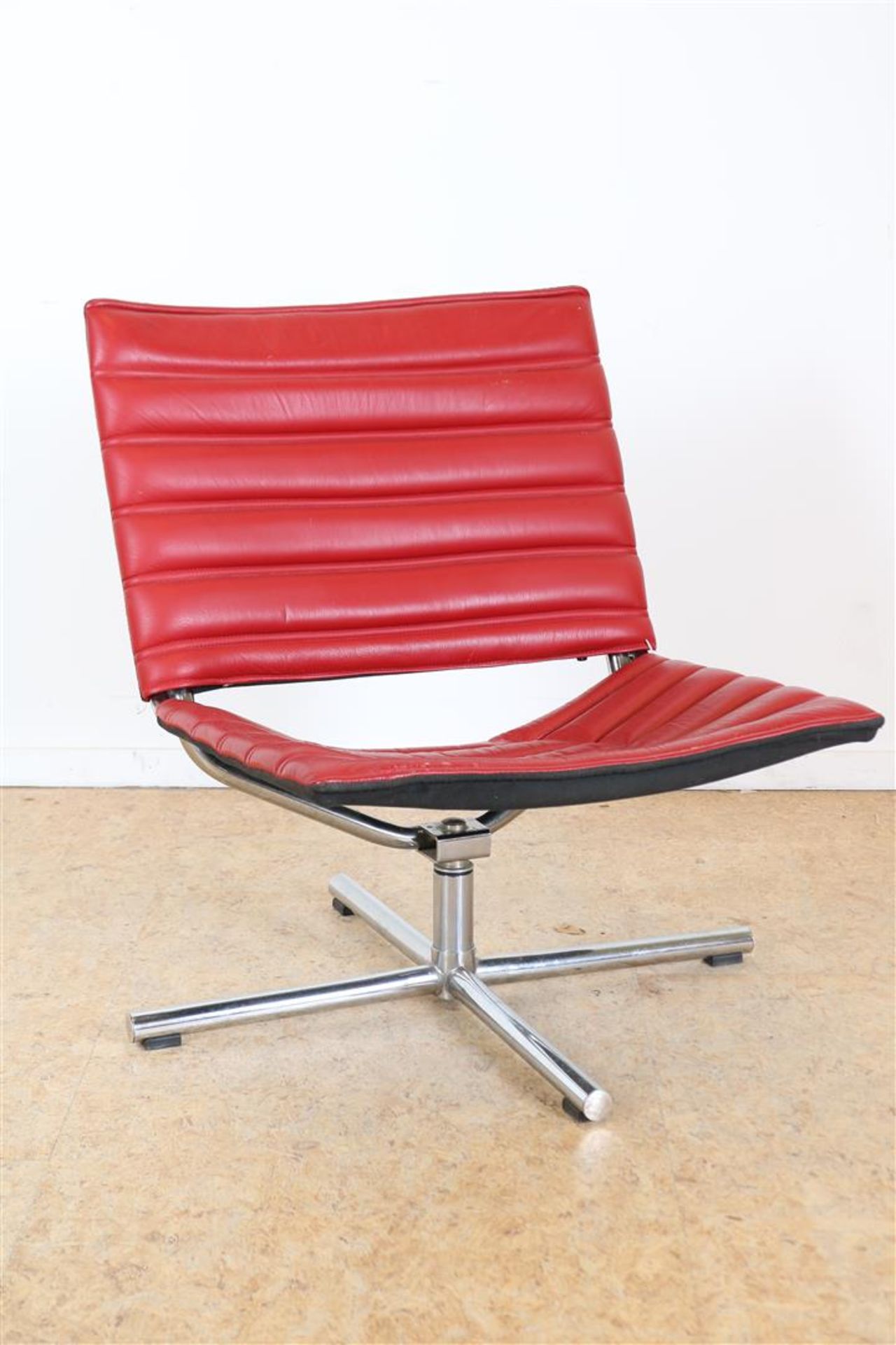 Red leather swivel armchair on chrome base. Model 'LAZY' by Hulshoff Design (The Hague).