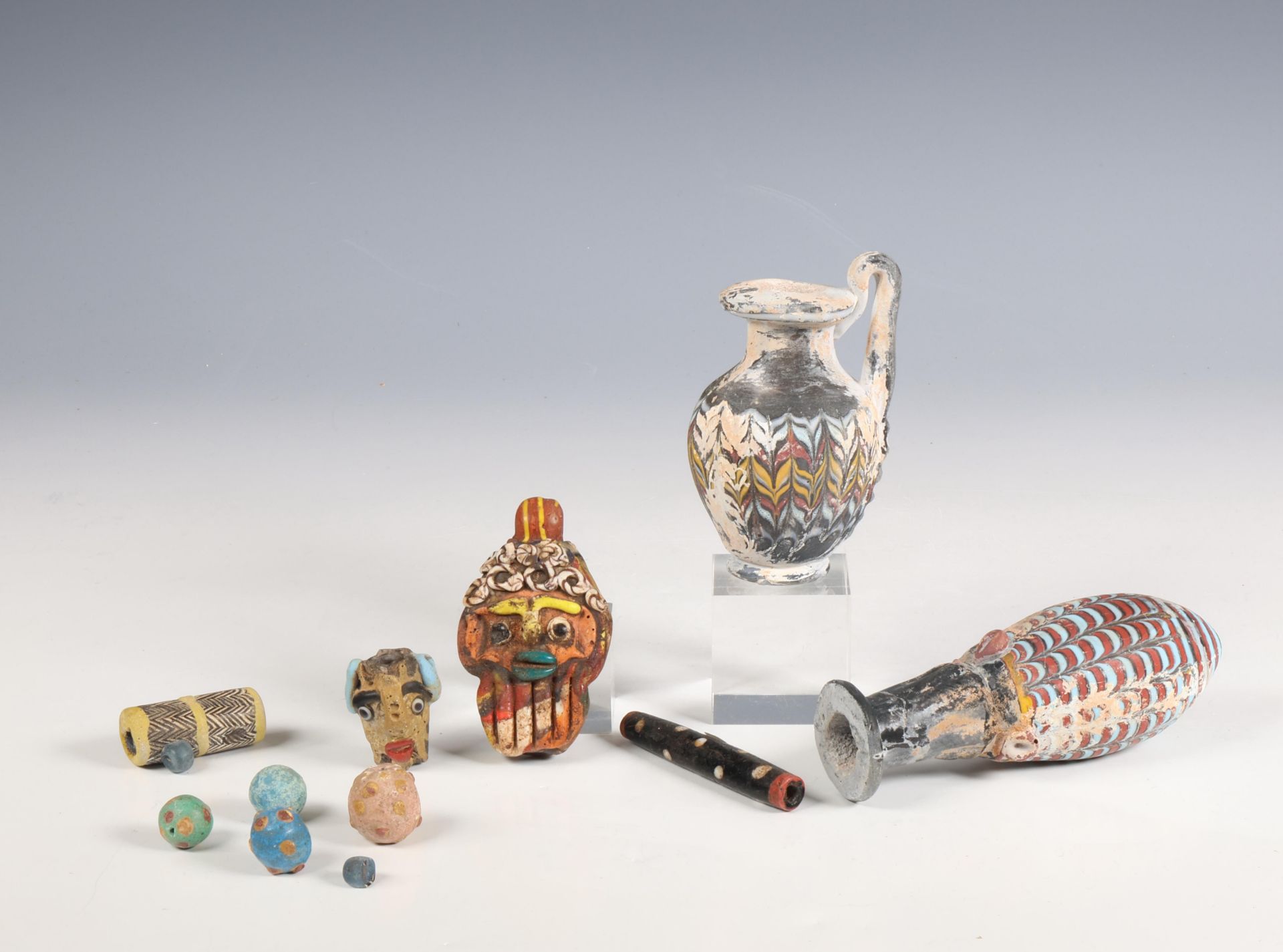 Phoenician style glass face beads, two style glass flask and various glass beads.