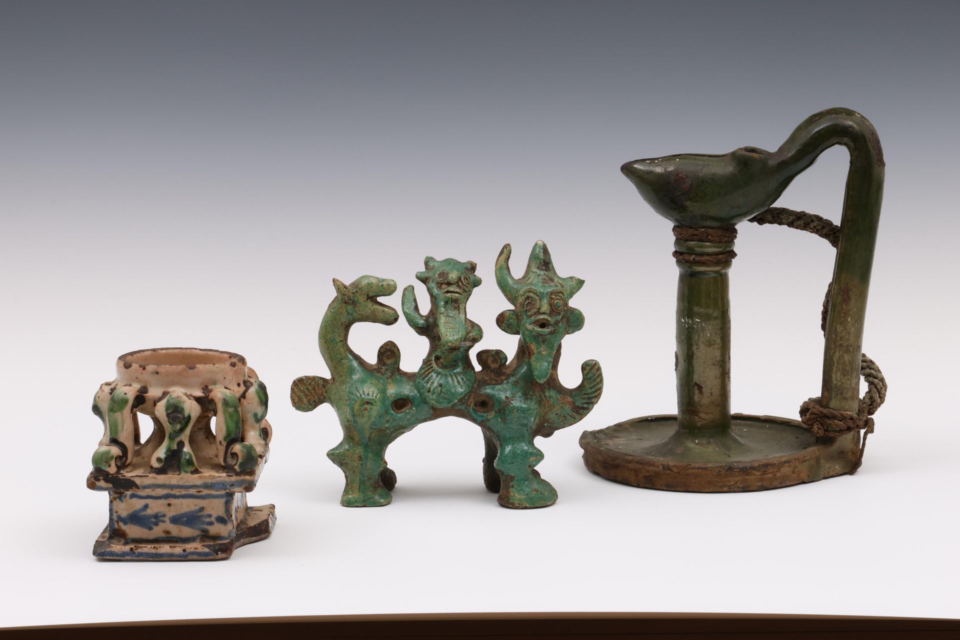 Iran, a green ceramic oil lamp, a mythological figure group and a faience tazza, 19th century and la