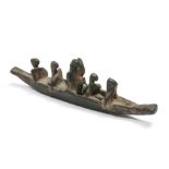 A antique bronze sculpture of five figures in a boat,