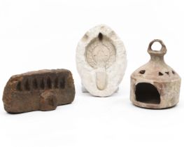 A Near Eastern large terracotta oil lamp, a stone oil lamp and a stucco mold for an oil lamp.