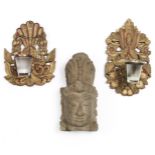 Java, two wooden wall brackets for oil lamps; herewith a stone Hindu head of a god.