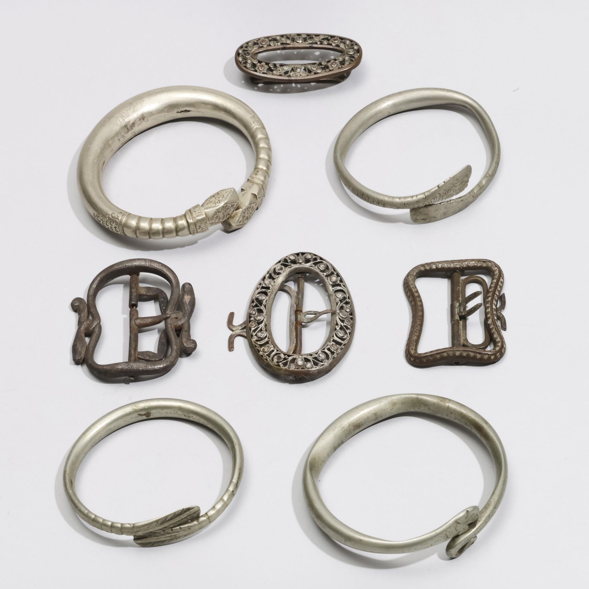 Indonesia, a collection of four Javanese buckles and four metal bangles.
