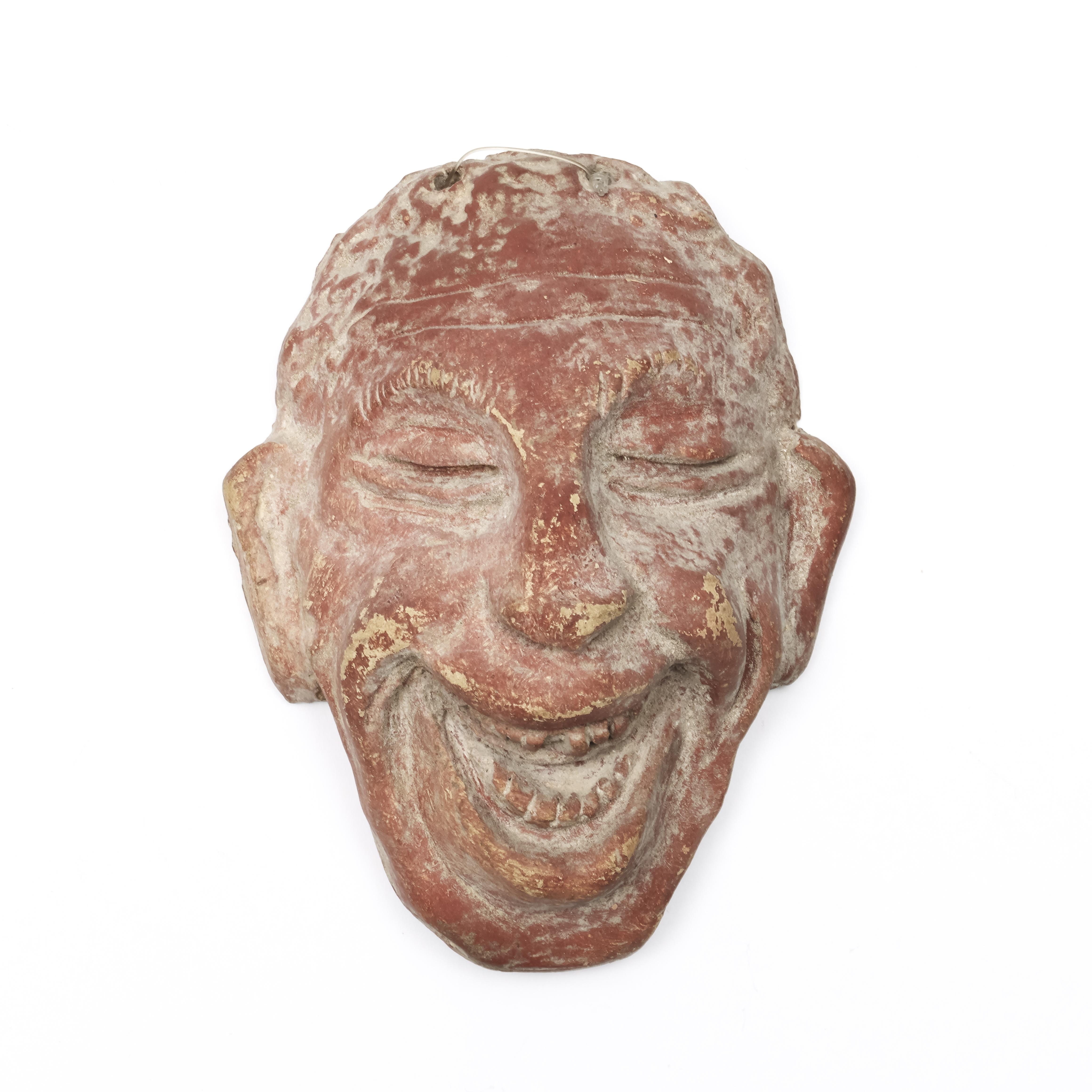 A red terracotta comic mask, possibly Hellinistic, ca. 1st century BC.