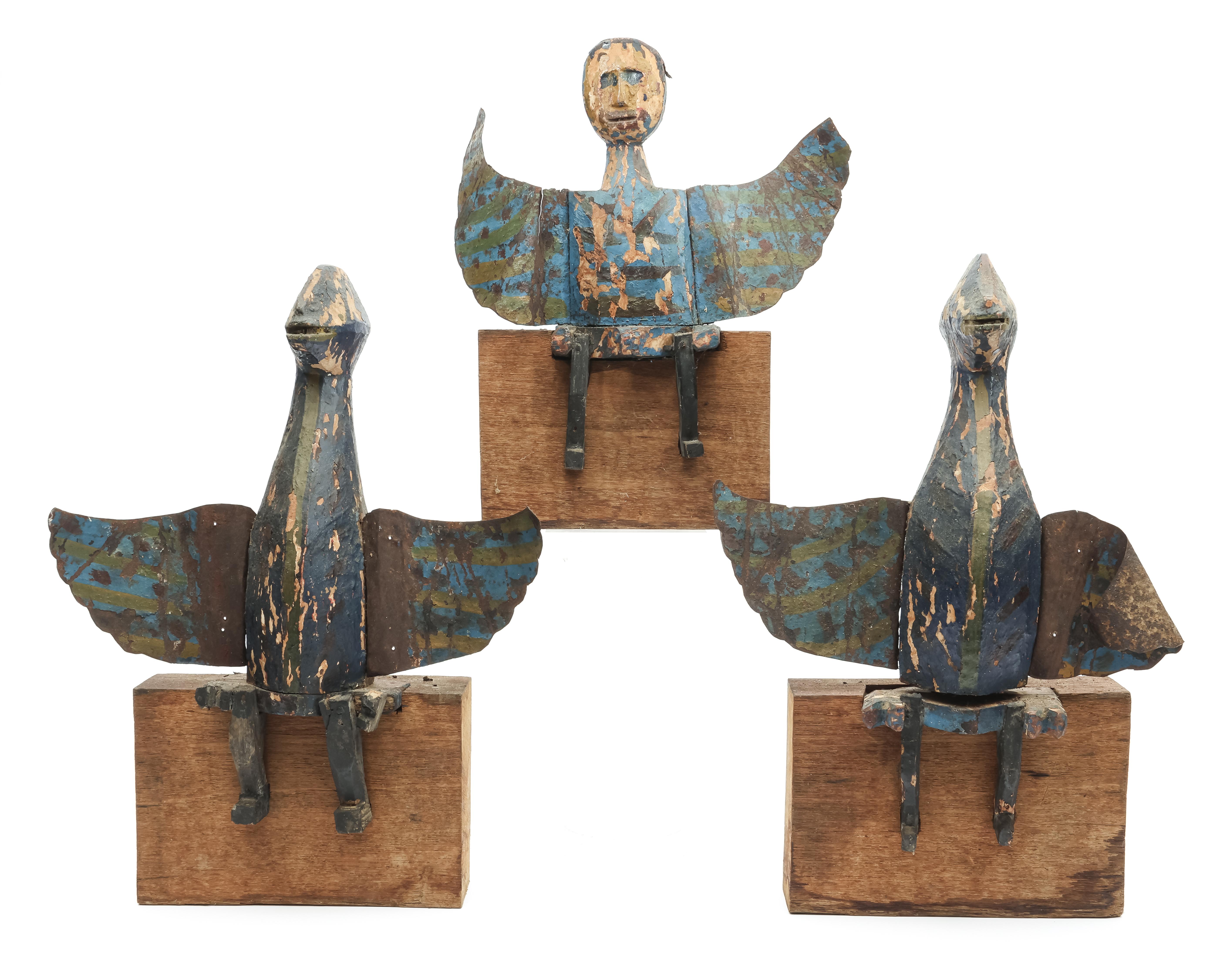 India, three painted wooden figures with metal wings on wooden stands.