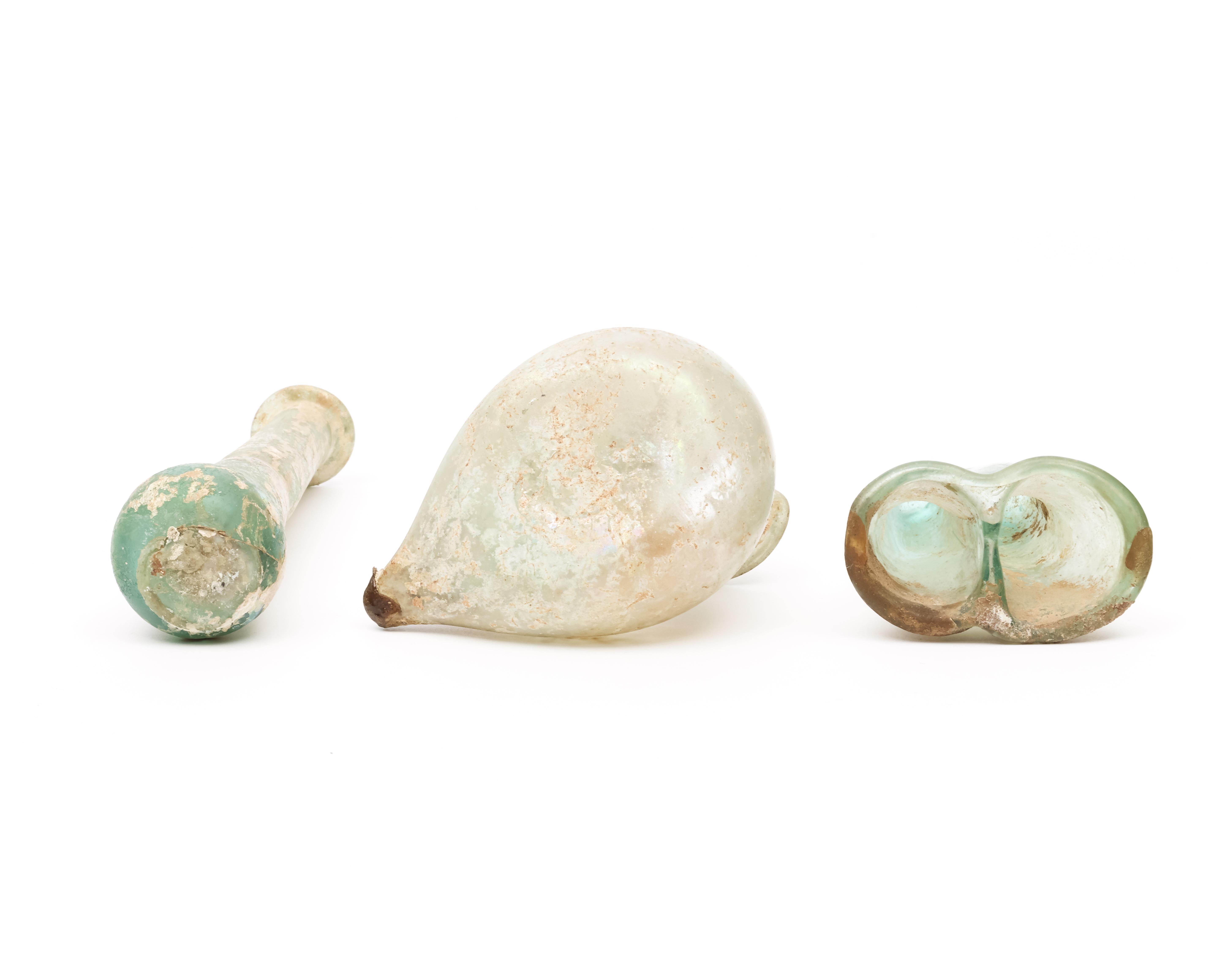 A Roman glass double balsamarium, a bird sprinkler and a long flask, 3r Century BC - Image 2 of 5