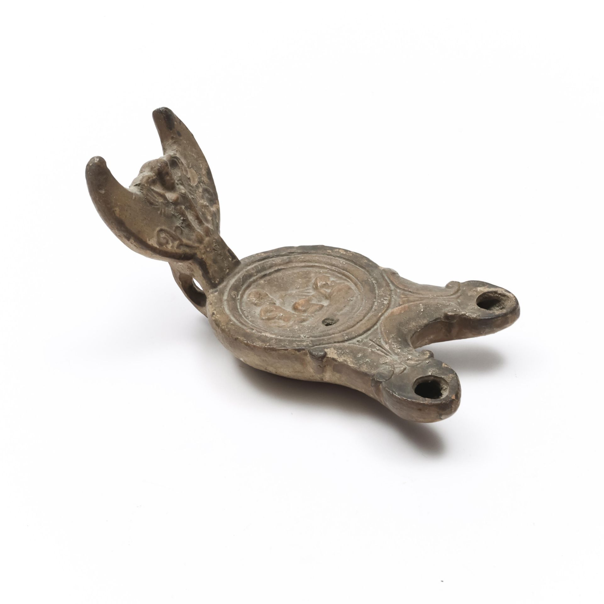 A Roman terracotta oil lamp with double sprout ca. 1st century AD.,