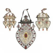 Turkmenistan, three silver, gilt-silver and cornelian pendants,