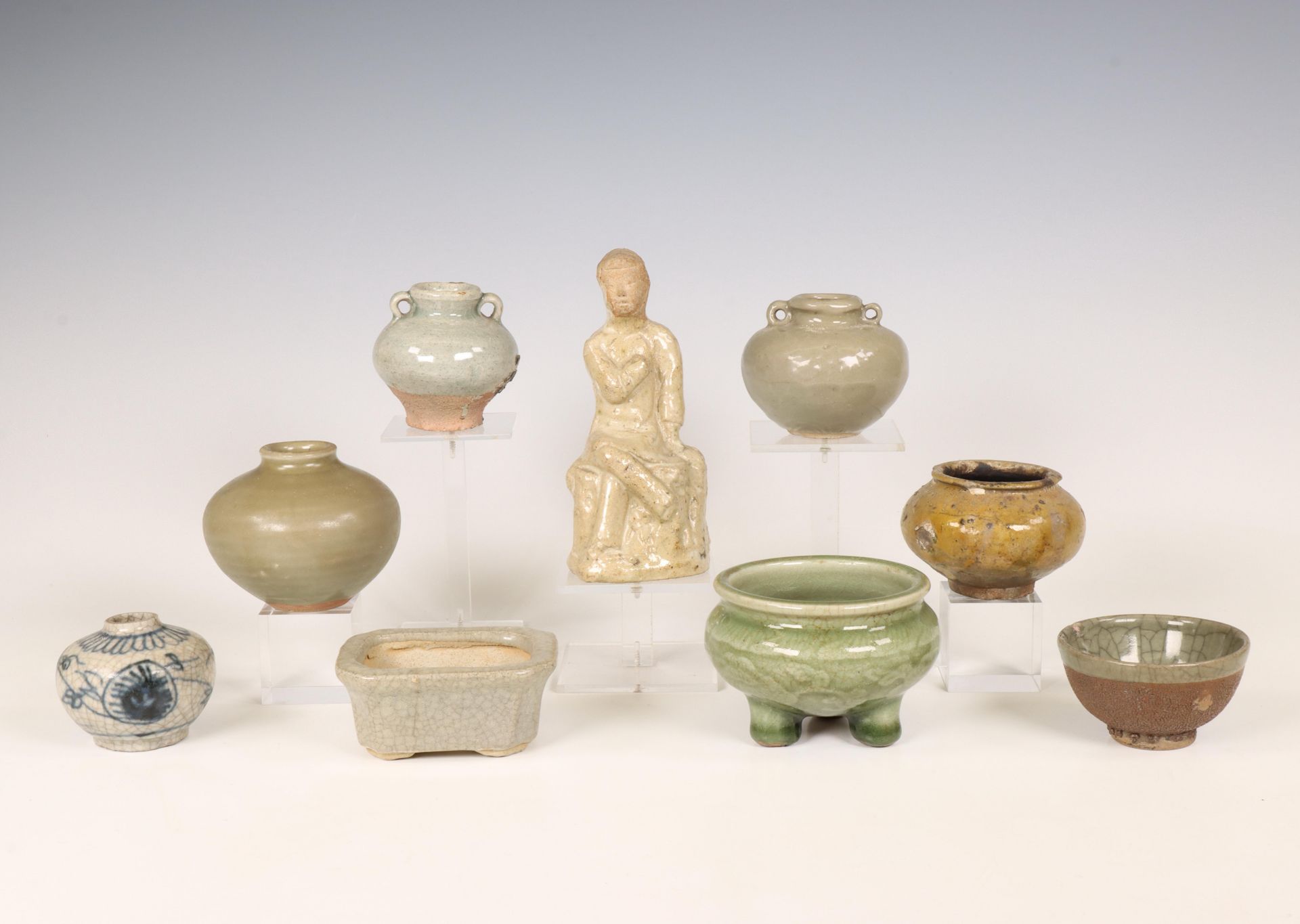 China and Southeast Asia, a collection of celadon and cream-glazed jars and a figure, Ming dynasty (