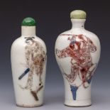 China, two blue and white and iron-red porcelain 'warrior' snuff bottles and stoppers, 19th century,