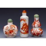 China, three iron-red decorated porcelain snuff bottles and stoppers, late 19th/ 20th century,