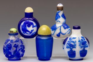 China, five blue overlay glass and blue glass snuff bottles and stoppers, 19th century,