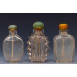 China, three translucent glass snuff bottles and stoppers, late Qing dynasty (1644-1912),