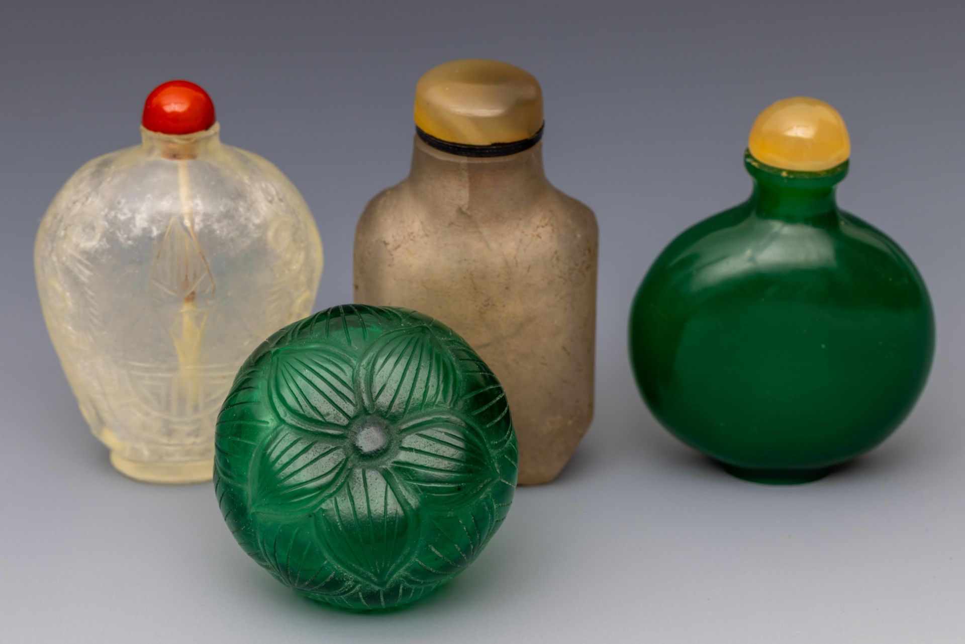 China, four green and translucent glass snuff bottles and stoppers, late Qing dynasty (1644-1912),