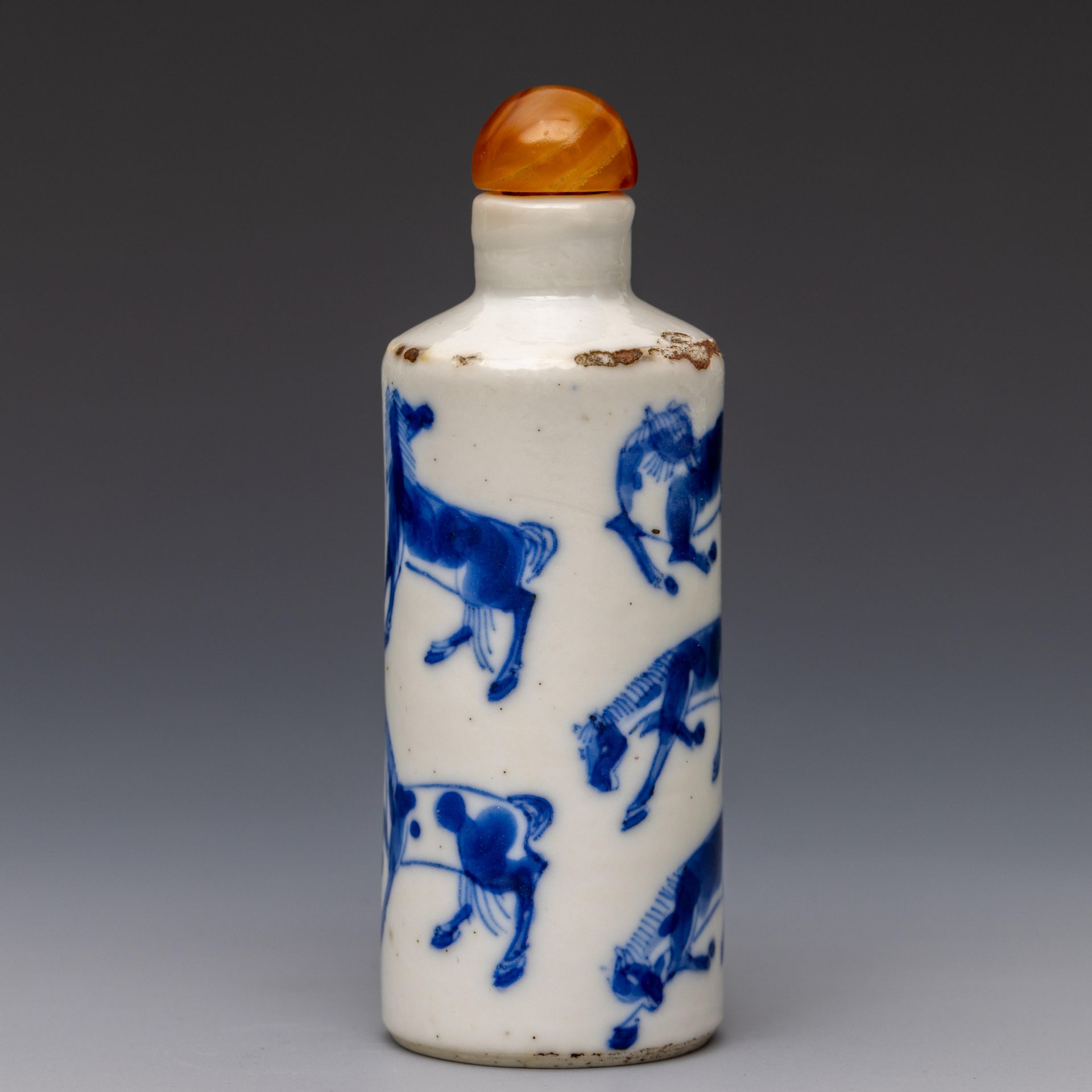 China, a blue and white and iron-red porcelain 'eight horses' snuff bottle and stopper, 19th century