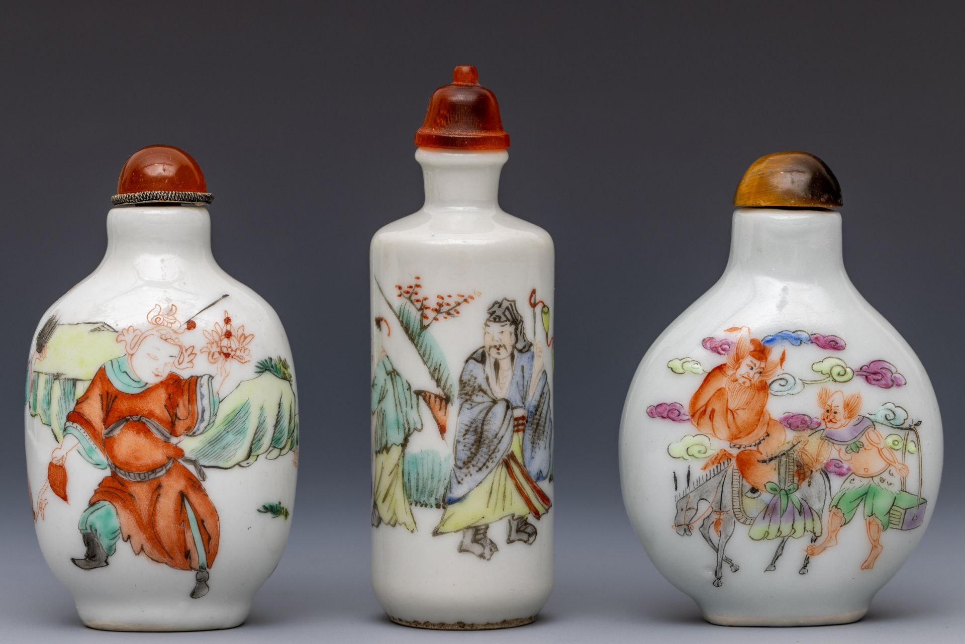 China, three polychrome decorated porcelain figural snuff bottles and stoppers, late Qing dynasty (1