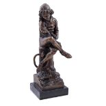 Bronze statue of a sitting boy on a mooring post