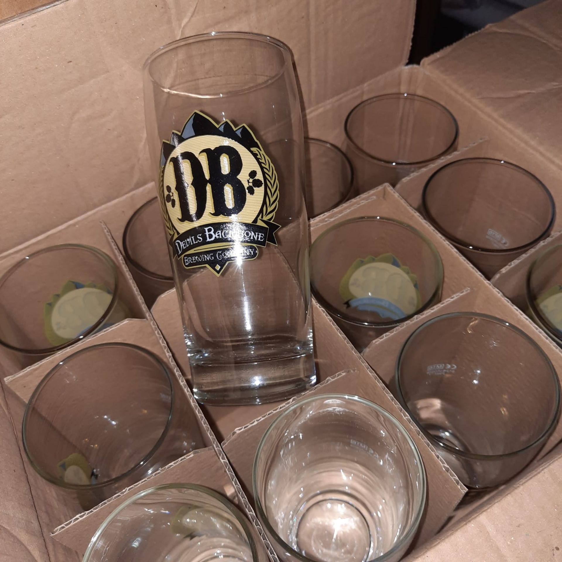 X 48 NEW & BOXED JUBLLE DEVILS BACKBONE BEER PINT GLASSES - SALEROOM AT THE BOTTOM OF ROW (E).