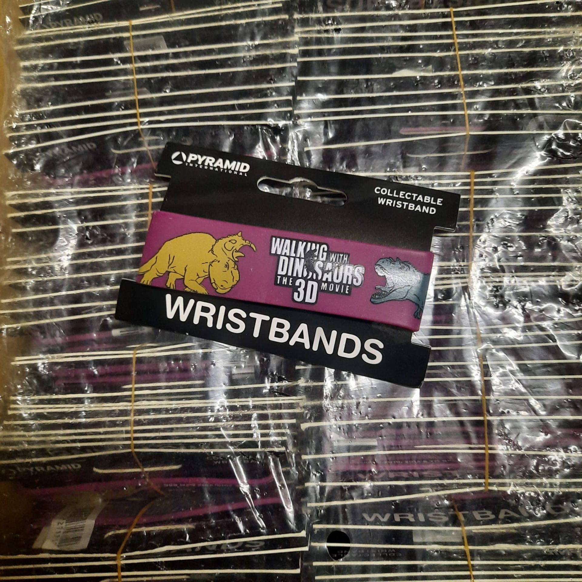 X 600 BRAND NEW & BOXED WALKING WITH DINOSAURS 3D WRISTBANDS - SALEROOM AT THE BOTTOM OF ROW (C).