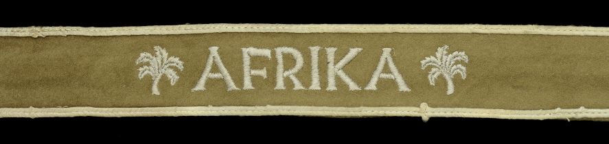 An 'Afrika' Cuffband. Soft mid-brown felt, with white cotton machine woven lettering, and w...