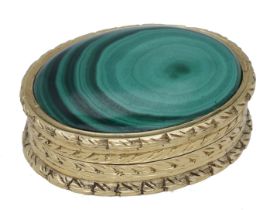 An oval gold pill box, the lid inset with malachite panel, within repeating engraved foliate...