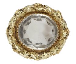 A mid 19th century smoky quartz brooch, the oval-cut smoky quartz in a gold surround of scro...