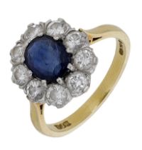 An 18ct gold sapphire and diamond cluster ring, the oval mixed-cut sapphire claw-set within...