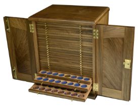 A wooden coin cabinet by R. Davis, 29.5 x 24 x 35cm, comprising 26 trays single-pierced to h...