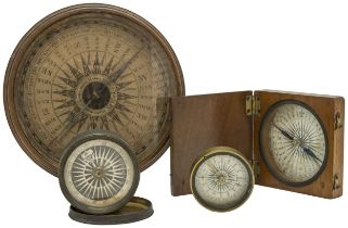 A WOODEN CASED POCKET COMPASS, a small brass cased compass, another smaller with a transit lock