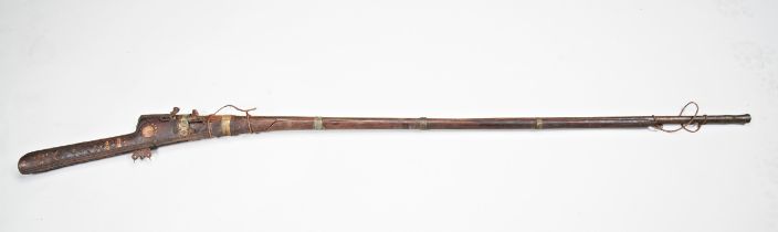 A INDIAN 19TH CENTURY MATCHLOCK GUN, the stock variously decorated and inlaid with brass and camel