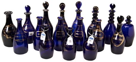 A COLLECTION OF SEVENTEEN BRISTOL-BLUE DECANTERS 18TH / 19TH CENTURY most with gilt faux spirit