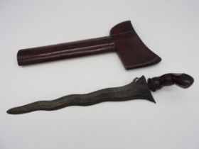 AN INDONESIAN KRIS, the ornately forged wavy blade with an exotic wood warangka and curved bulbus