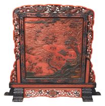 A JAPANESE CARVED RED AND BLACK SCREEN MEIJI PERIOD carved with figures in a rural river side