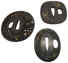 A RETICULATED JAPANESE IRON TSUBA decorated with a dragon in a stylised sky, a pagoda and a fish,