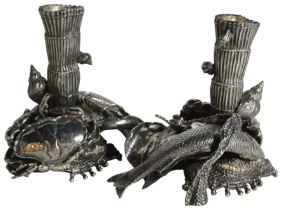 A pair of Italian silver candlesticks with crabs and fish upon a scrolled base