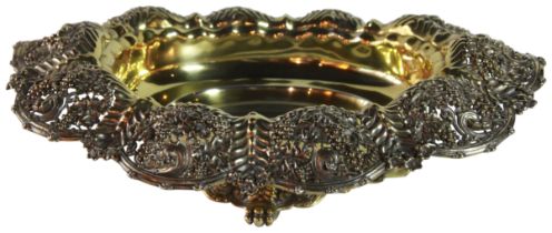 A magnificent silver gilt centerpiece/ bowl with vine scrolled decoration upon paw feet. Stamped