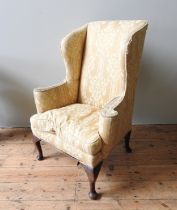 A MID 18TH CENTURY WING CHAIR, with scroll form wings and out scrolling arms, with a squab