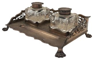 A SILVER INKSTAND THE RETICULATED UPSTAND AROUND TWO SILVER-TOPPED GLASS INKWELLS and upon paw