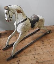 A LARGE VINTAGE CARVED WOODEN ROCKING HORSE, cream painted with a leather saddle, missing the