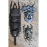 A CAST BRONZE TRIBAL MASK, SMALLER BRONZE MASK AND A HARDWOOD MASK, the larger bronze mask