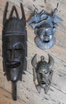 A CAST BRONZE TRIBAL MASK, SMALLER BRONZE MASK AND A HARDWOOD MASK, the larger bronze mask