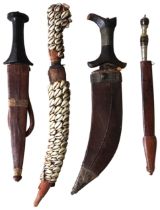 A NORTH AFRICAN JAMBIYA WITH TOOLED LEATHER SCABBARD, A NORTH AFRICAN DAGGER WITH COWRIE SHELL