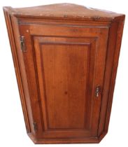 AN OAK GEORGE III CORNER CUPBOARD, the panelled door opening to reveal three interior shelves 44 x