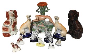 A MIXED GROUP OF 19TH CENTURY ENGLISH POTTERY DOG FIGURES, the lot includes a pair of seated