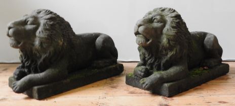 A PAIR OF ORNAMENTAL GARDEN LIONS, 20TH CENTURY, cast composite stone recumbent figures, of good